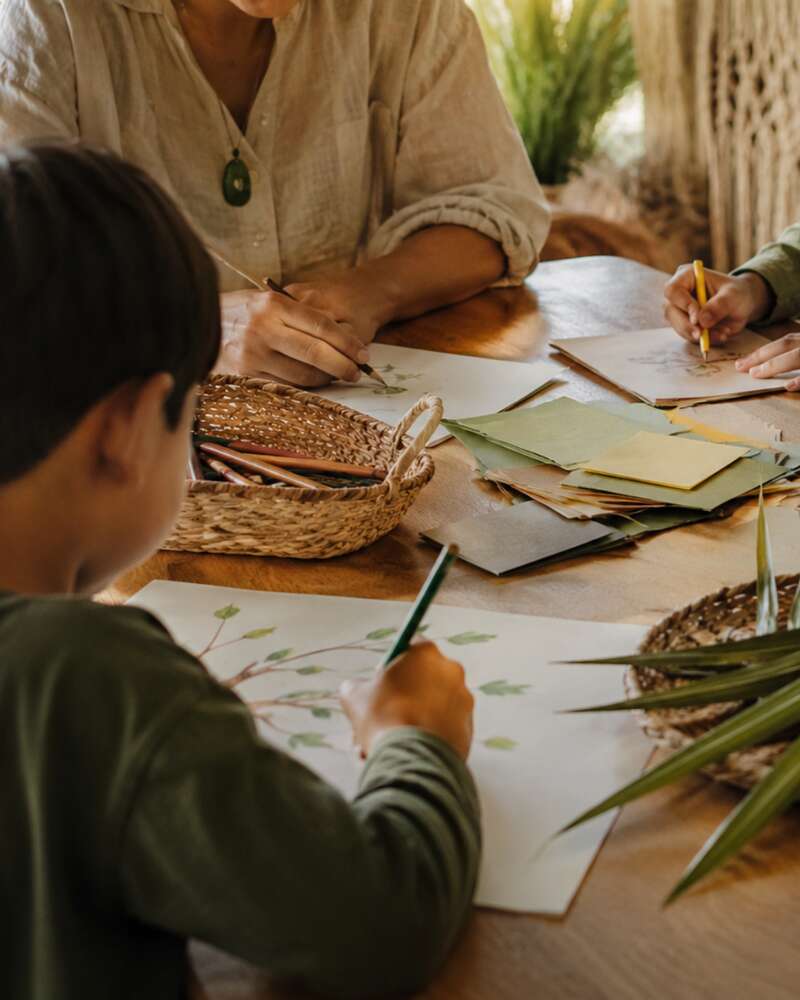 Image of family around table writing on paper